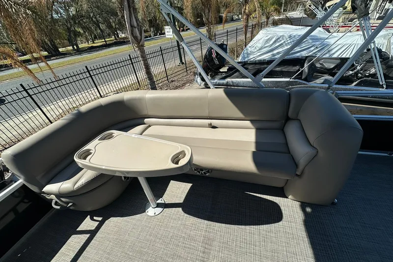 Slide: The Image of 2024 Ranger Reata 200C boat interior with beige seating and a small table. - 17