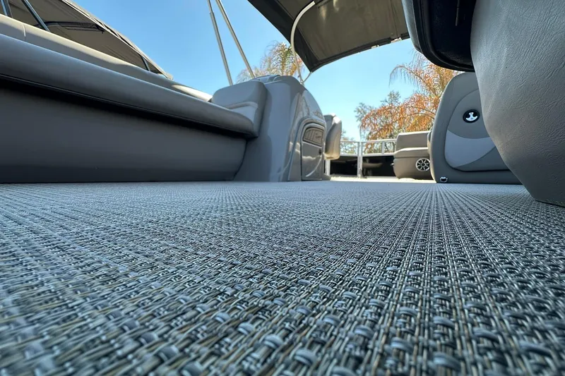 Slide: The Image of 2024 Ranger Reata 200C interior with textured flooring and seating, under a clear blue sky. - 21
