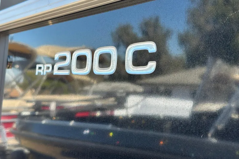 Slide: The Image of 2024 Ranger Reata 200C boat logo with reflective surface in outdoor setting. - 26