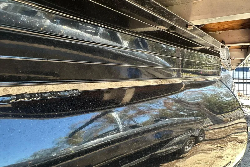 Slide: The Image of 2024 Ranger Reata 200C boat with sleek black exterior and reflective surface. - 27