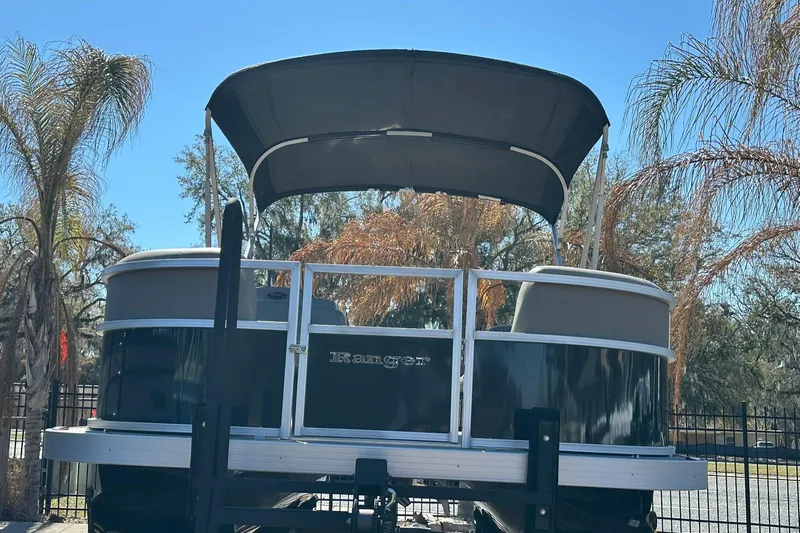 Slide: The Image of 2024 Ranger Reata 200C pontoon boat with canopy, surrounded by palm trees. - 3