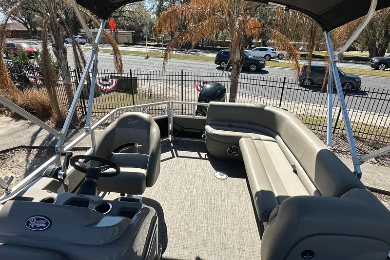 Slide: The Image of 2024 Ranger Reata 200C pontoon boat interior with seating and steering console. - 7