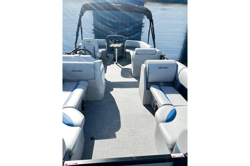 Slide: The Image of 2025 Bentley 223 Bolt Tri Toon boat interior with luxurious seating and steering console. - 4