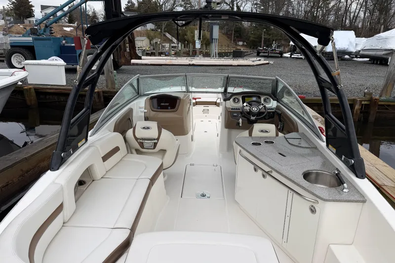 Slide: The Image of 2016 Chaparral 264 Sunesta boat interior with seating, helm, and kitchenette. - 8