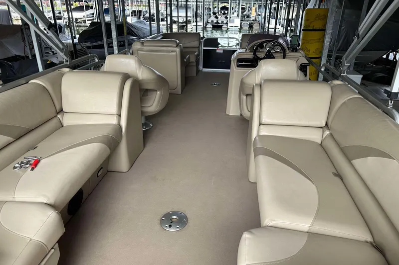 Slide: The Image of 2013 SunCatcher V322 RC boat interior with beige seating and steering console. - 14