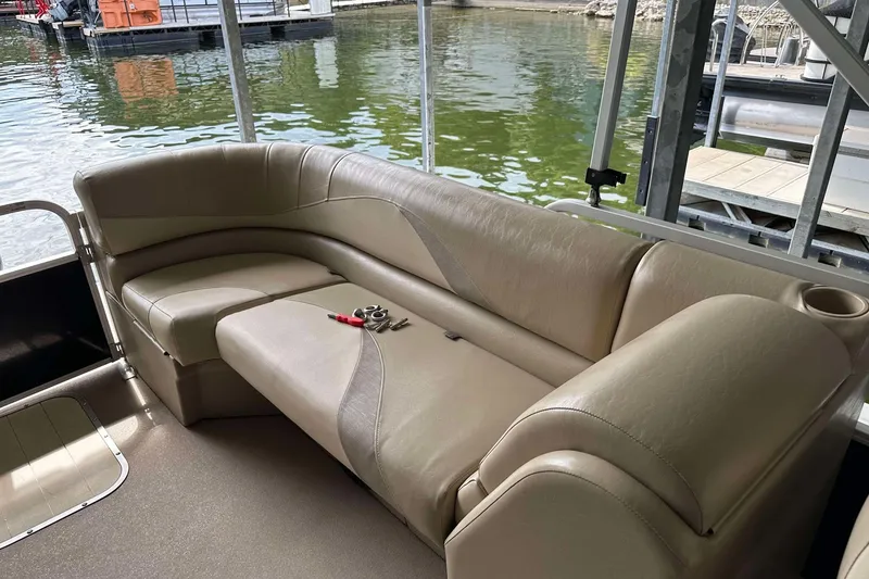 Slide: The Image of 2013 SunCatcher V322 RC pontoon boat interior with beige seating and lake view. - 16