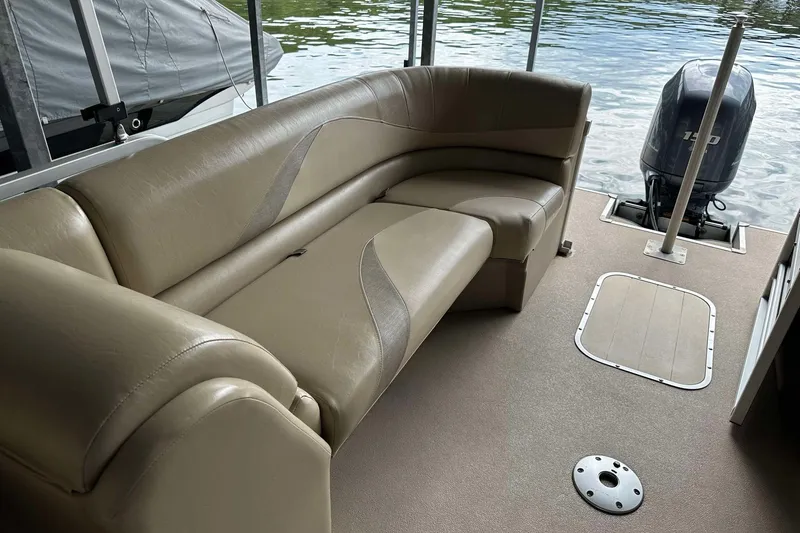 Slide: The Image of 2013 SunCatcher V322 RC boat interior with beige seating and outboard motor. - 9