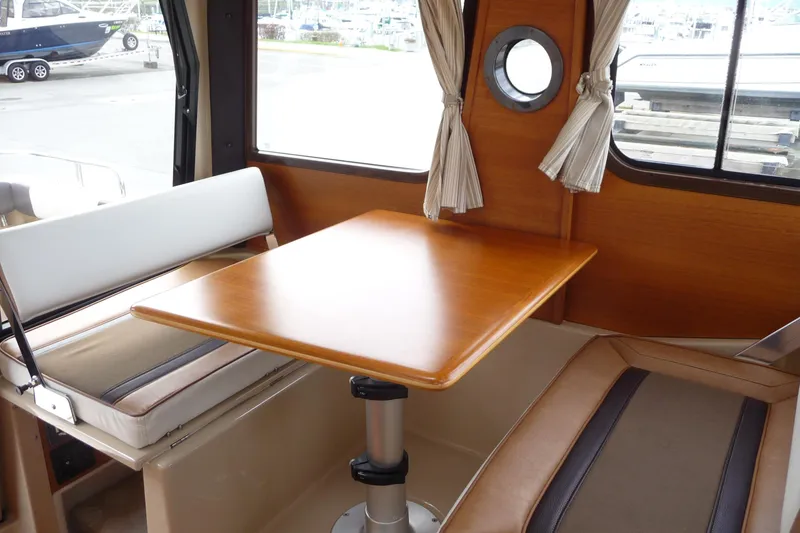 Slide: The Image of Interior of 2017 Ranger Tugs R-23 boat with wooden table and seating. - 12