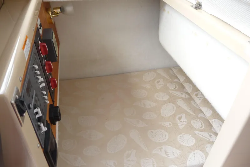 Slide: The Image of 2017 Ranger Tugs R-23 cabin interior with control panel and patterned bedding. - 20