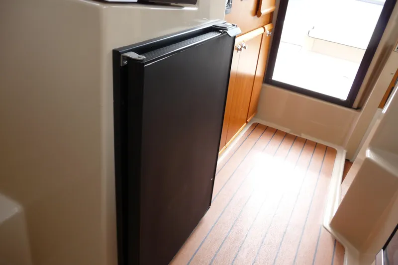 Slide: The Image of Interior of 2017 Ranger Tugs R-23 boat with compact black refrigerator. - 24