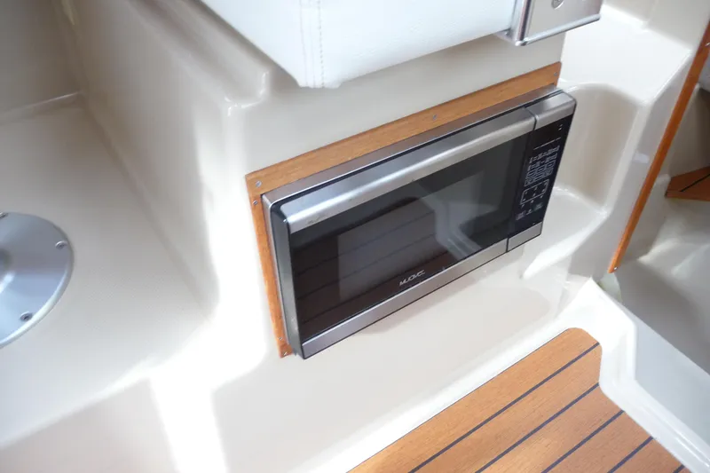 Slide: The Image of 2017 Ranger Tugs R-23 interior with built-in microwave and wood accents. - 25