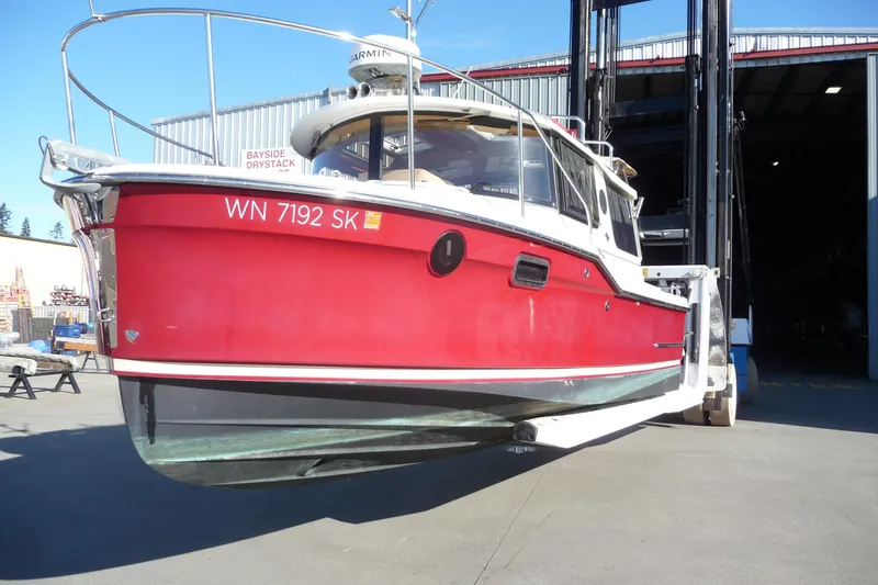 Slide: The Image of 2017 Ranger Tugs R-23 boat in red, lifted by forklift at Bayside Drystack. - 3