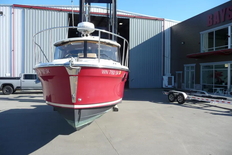 Slide: The Image of 2017 Ranger Tugs R-23 boat in front of a warehouse, red hull, on a trailer. - 4