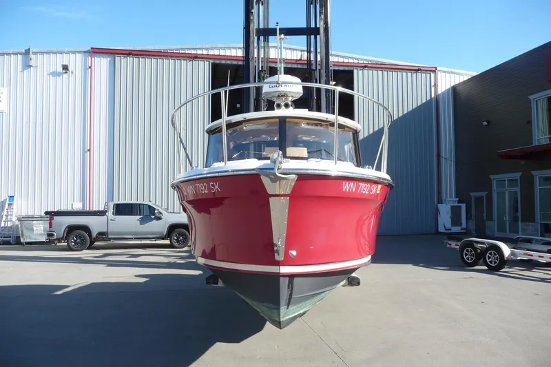Slide: The Image of 2017 Ranger Tugs R-23 boat in red, parked outside a warehouse. - 7