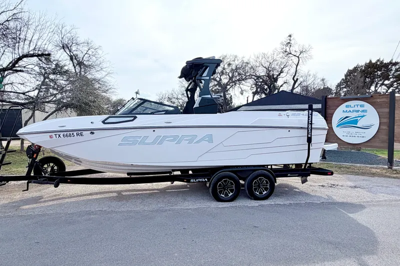 Slide: The Image of 2023 Supra SE 550 boat on trailer at Elite Marine dealership. - 10