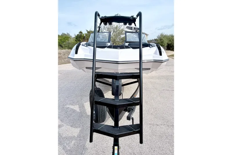 Slide: The Image of 2023 Supra SE 550 boat on trailer with ladder, parked on a road. - 16