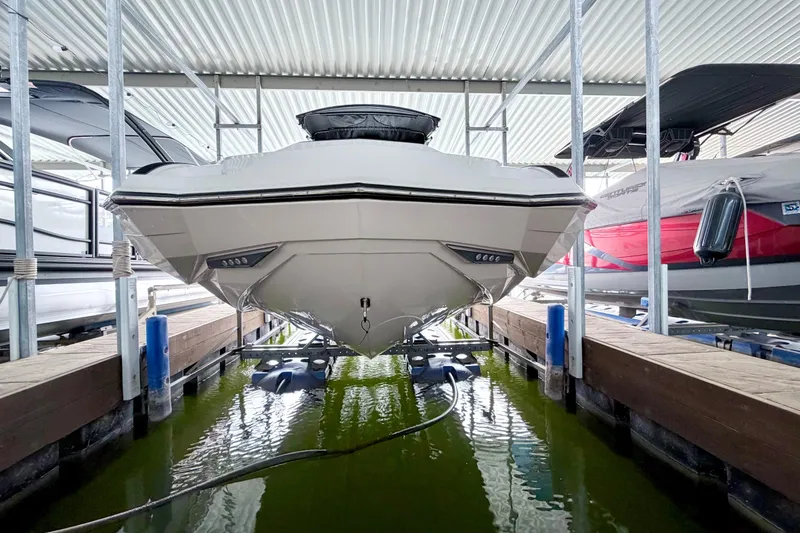 Slide: The Image of 2023 Supra SE 550 boat docked in a covered marina, front view. - 20