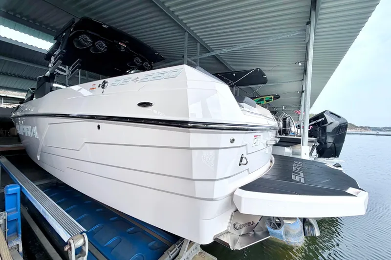 Slide: The Image of 2023 Supra SE 550 boat docked under a covered marina, showcasing sleek design and modern features. - 22