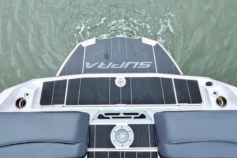 Slide: The Image of 2023 Supra SE 550 boat deck with sleek design on water. - 24
