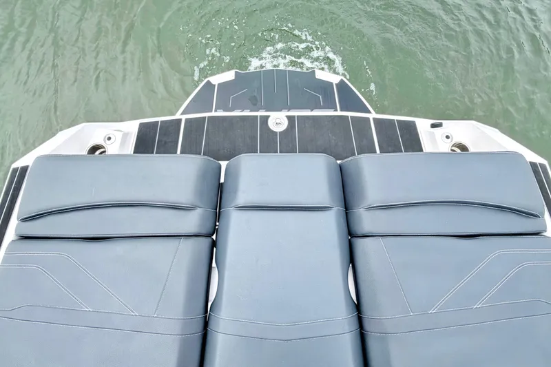 Slide: The Image of 2023 Supra SE 550 boat with sleek seating and deck design on water. - 25