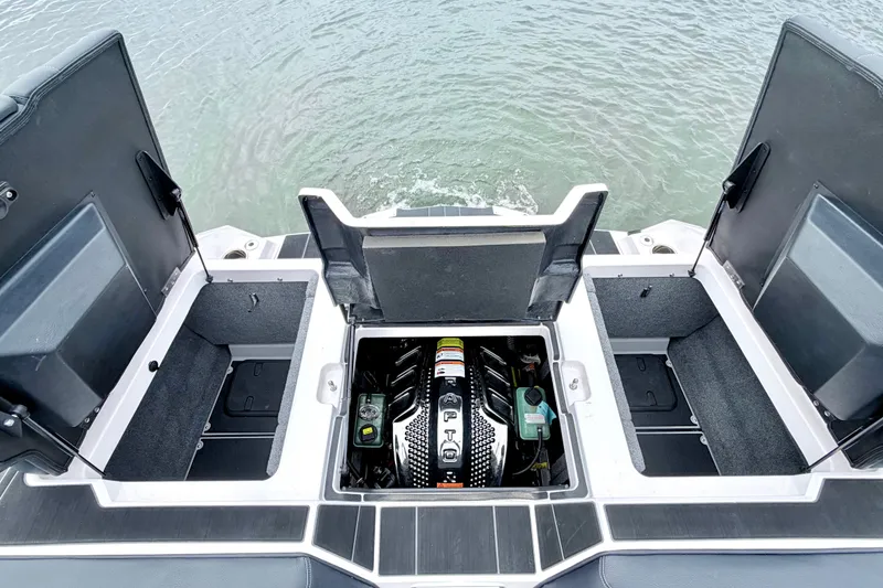 Slide: The Image of 2023 Supra SE 550 boat engine compartment with open storage hatches, on water. - 26