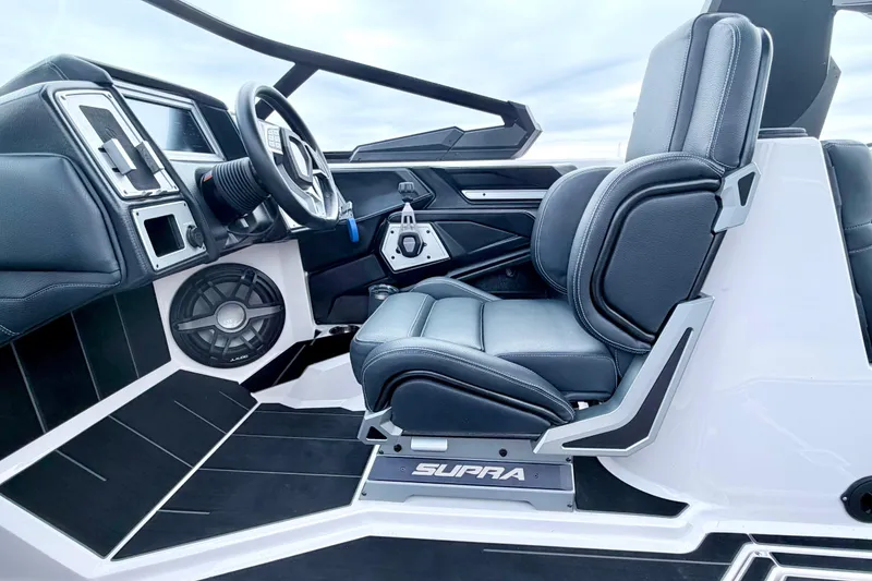 Slide: The Image of 2023 Supra SE 550 boat interior with sleek black seating and modern dashboard design. - 34