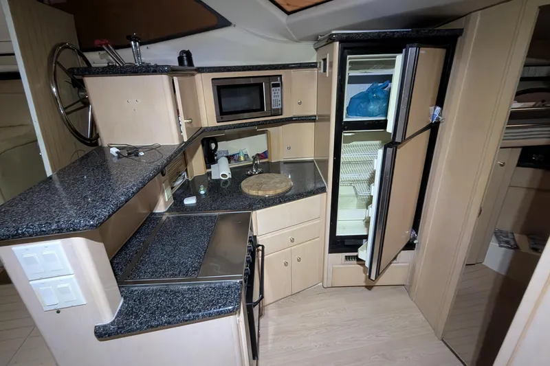 Slide: The Image of 2000 Carver 404 Cockpit Motor Yacht kitchen with granite countertops and open fridge. - 21