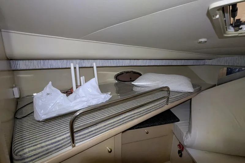 Slide: The Image of Interior cabin of 2000 Carver 404 Cockpit Motor Yacht with striped bedding and storage. - 22