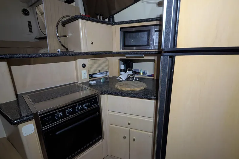 Slide: The Image of Kitchen area of 2000 Carver 404 Cockpit Motor Yacht with stove, microwave, and cabinets. - 23