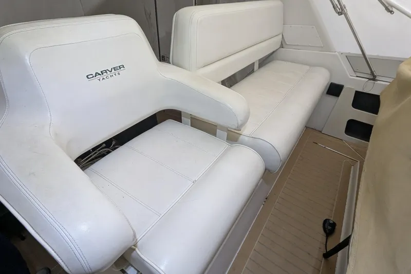 Slide: The Image of White seating area on 2000 Carver 404 Cockpit Motor Yacht, featuring Carver Yachts branding. - 5