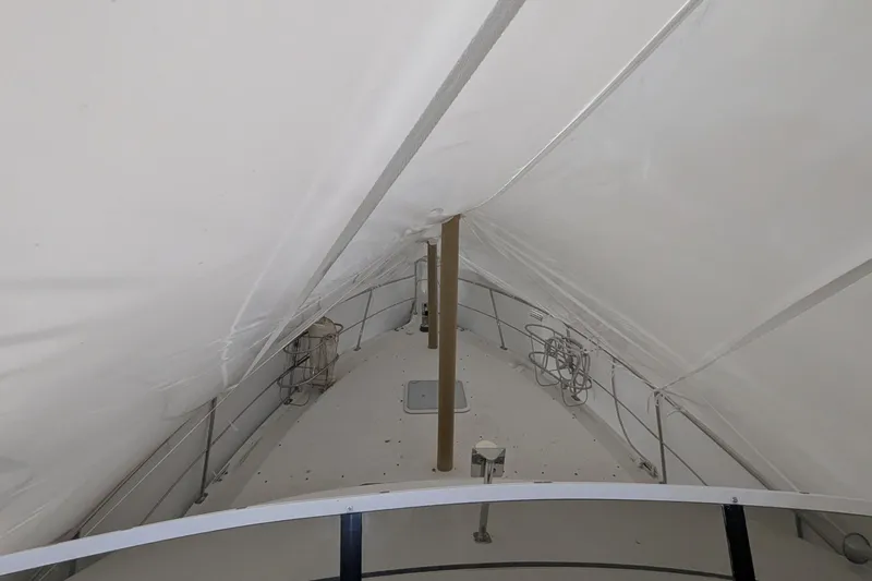 Slide: The Image of 2000 Carver 404 Cockpit Motor Yacht under protective cover, showcasing deck details. - 6