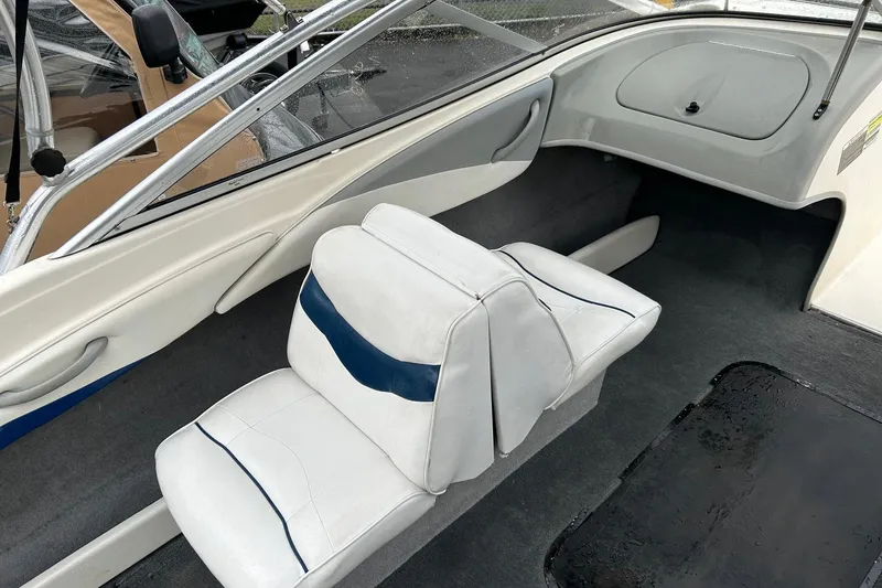 Slide: The Image of 2004 Bayliner 205 boat interior with white and blue seating, clean and spacious design. - 11
