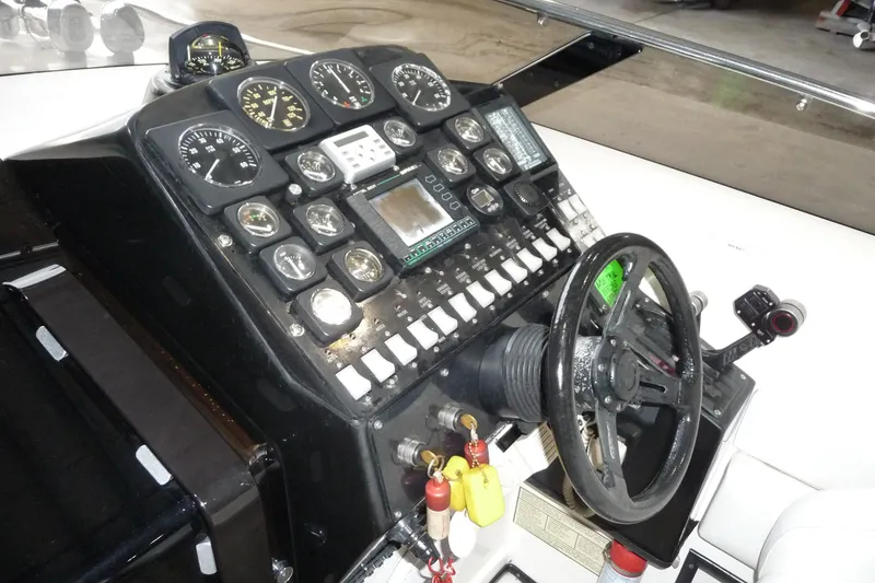 Slide: The Image of Dashboard of a 1989 Baja 280 Sportfish boat with gauges and steering wheel. - 13