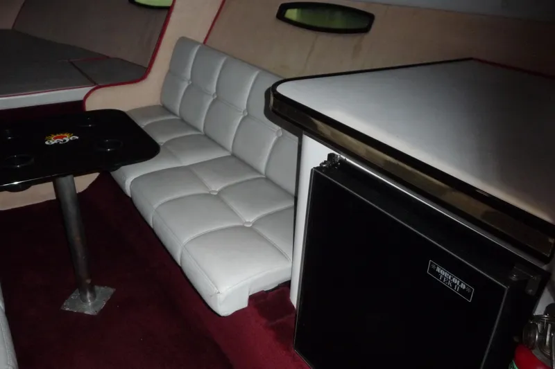 Slide: The Image of Interior of 1989 Baja 280 Sportfish with white seating, table, and mini fridge. - 18
