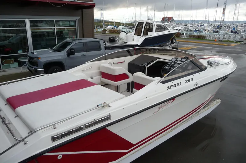 Slide: The Image of 1989 Baja 280 Sportfish boat with red and white interior, docked near a marina. - 31
