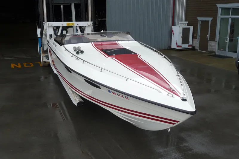 Slide: The Image of 1989 Baja 280 Sportfish boat with red and white design on a wet dock. - 9