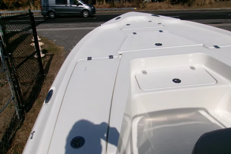 Slide: The Image of 2026 Key West 210 Bay Reef boat deck with storage compartments, parked near a road. - 11