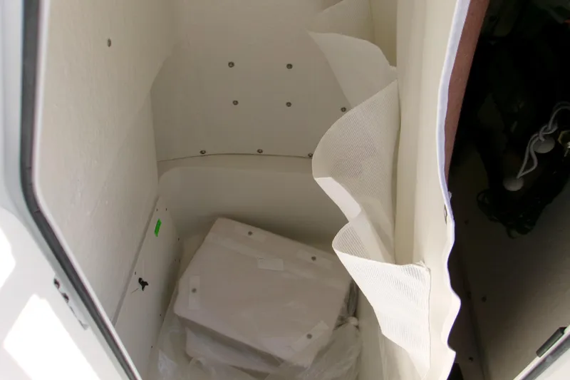 Slide: The Image of Storage compartment inside 2026 Key West 210 Bay Reef boat, featuring white interior and equipment. - 12