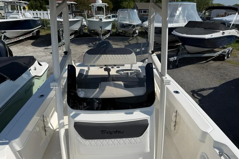 Slide: The Image of 2026 Bayliner Trophy T20CC boat interior with steering console, surrounded by other boats. - 10