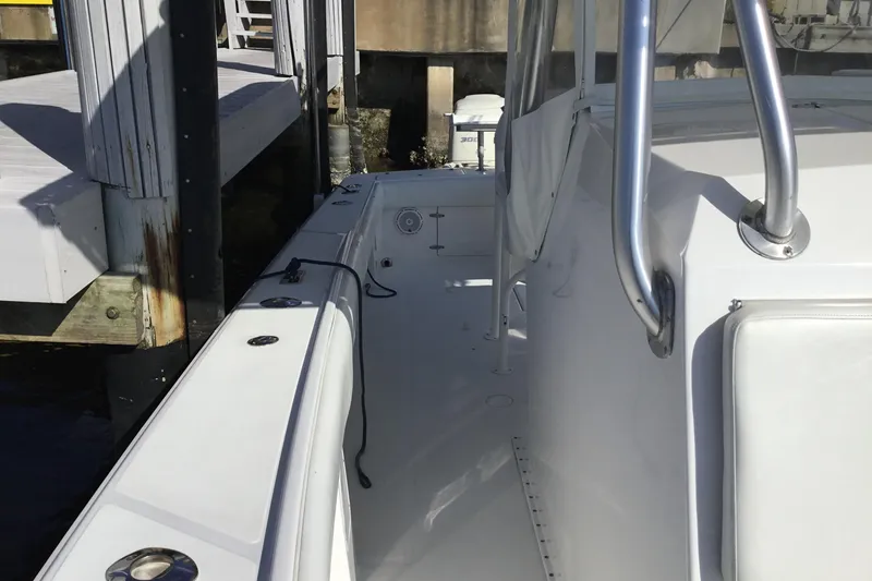 Slide: The Image of 2000 Jupiter 31 Center Console boat docked, showcasing sleek white design and stainless steel railings. - 13