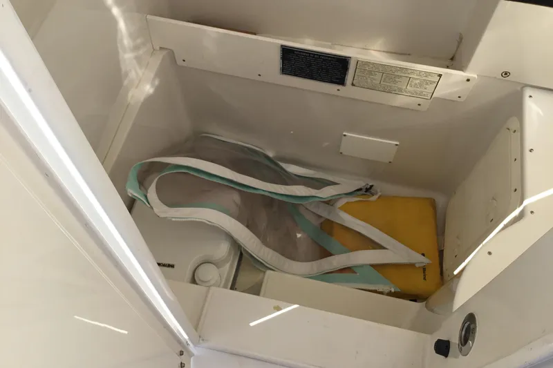 Slide: The Image of Storage compartment in a 2000 Jupiter 31 Center Console boat with life jackets and equipment. - 23