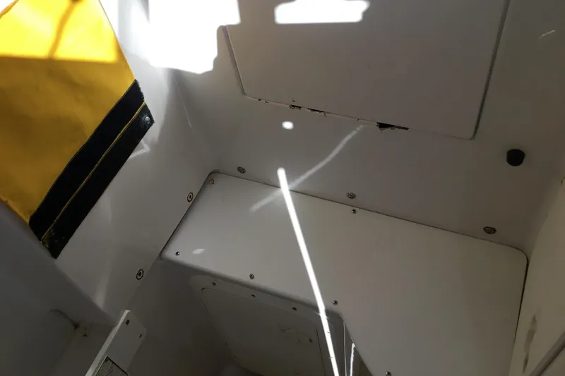 Slide: The Image of Interior view of a 2000 Jupiter 31 Center Console boat, featuring a yellow fabric detail. - 24