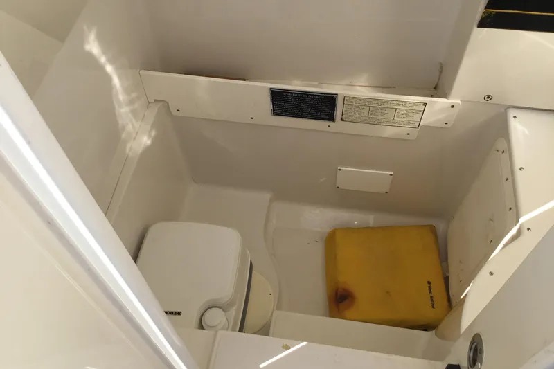 Slide: The Image of Interior of 2000 Jupiter 31 Center Console boat with storage compartment and portable toilet. - 25
