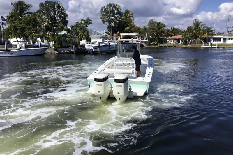 Slide: The Image of 2000 Jupiter 31 Center Console boat navigating a tropical waterway with palm trees. - 4
