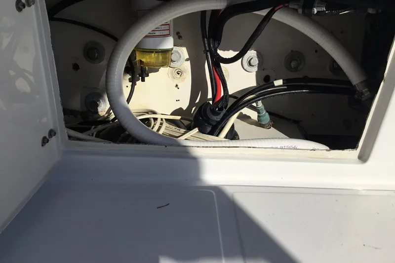 Slide: The Image of Engine compartment of a 2000 Jupiter 31 Center Console boat, showing cables and hoses. - 42