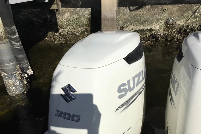 Slide: The Image of Twin Suzuki 300 outboard engines on a 2000 Jupiter 31 Center Console boat. - 49
