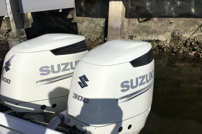Slide: The Image of Twin Suzuki 300 outboard engines on a 2000 Jupiter 31 Center Console boat. - 50