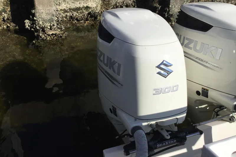 Slide: The Image of Twin Suzuki 300 outboard engines on a 2000 Jupiter 31 Center Console boat. - 51