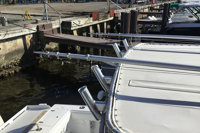 Slide: The Image of 2000 Jupiter 31 Center Console boat docked with fishing rod holders. - 59