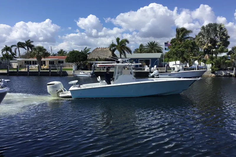 Slide: The Image of 2000 Jupiter 31 Center Console boat cruising on a sunny day near waterfront homes. - 62